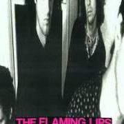 The lyrics GOD WALKS AMONG US NOW - JESUS SONG NO. 6 of THE FLAMING LIPS is also present in the album In a priest driven ambulance (1990)